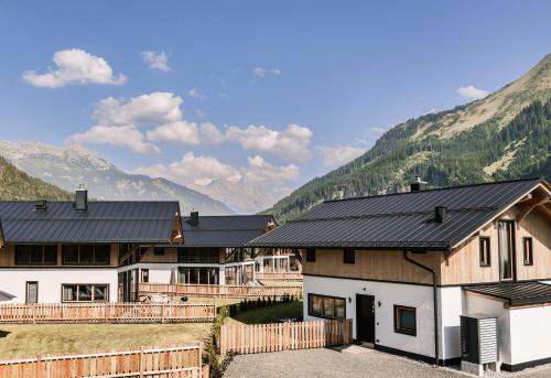a house with a fence and mountains in the background at Chalet DEIN BICHLBACH 8 Personen in Bichlbach