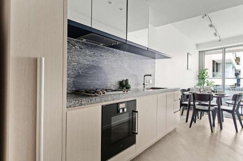 a kitchen with a stove and a table with chairs at Luxury Stay Near Grand Prix Track in Melbourne