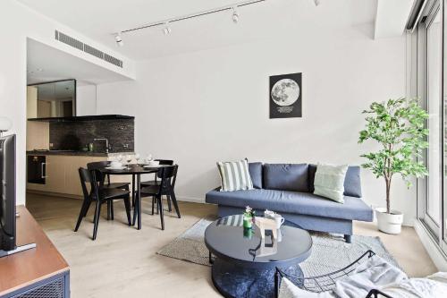 a living room with a blue couch and a table at Luxury Stay Near Grand Prix Track in Melbourne