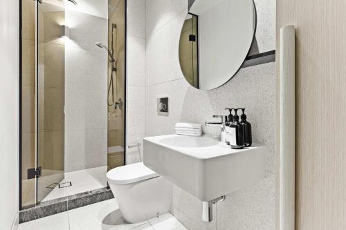 a bathroom with a sink and a toilet and a mirror at Luxury Stay Near Grand Prix Track in Melbourne