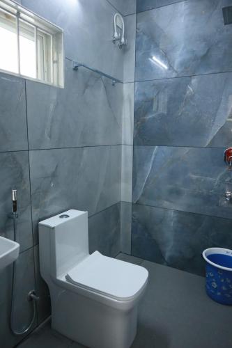 a bathroom with a white toilet and a shower at Shining Star in Alleppey