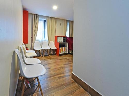 a group of white chairs in a room at Capital O 90574 Hotel Glo in Kuala Lumpur