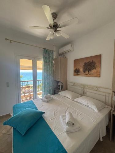 a bedroom with a bed with a ceiling fan at Moriel Seaside Homes Suites in Elia