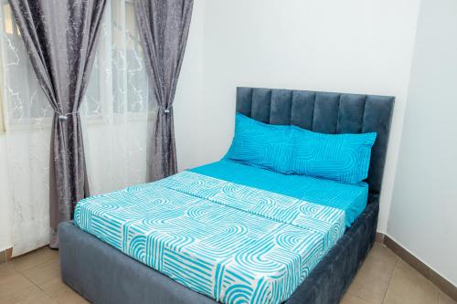 a bed with blue and white sheets and blue pillows at Appartement 1chambre centre-ville in Pointe-Noire