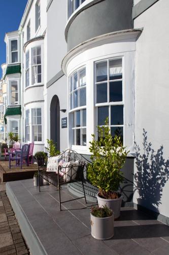 a porch with a bench and potted plants on a building at The View on the terrace in Weymouth
