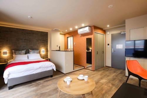 a bedroom with a bed and a table in a room at the Moto Hotel Shinjuku in Tokyo