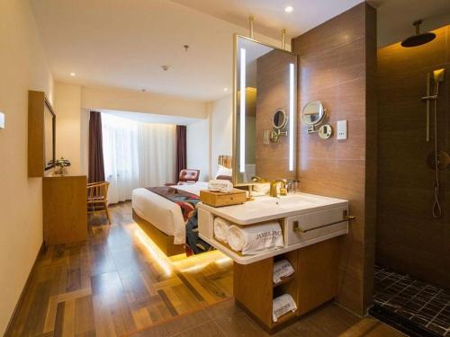 a bathroom with a bed and a sink and a mirror at James Joyce Coffetel· Hefei Anhui Agricultural University in Hefei