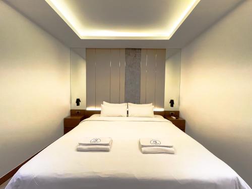 a bedroom with a bed with two towels on it at Riverside Hotel in Vientiane