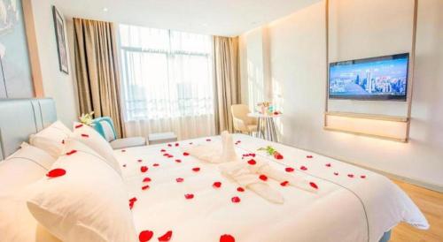 a bedroom with a white bed with red roses on it at Magnotel Hotel Dongxing Guomen Port in Fangcheng