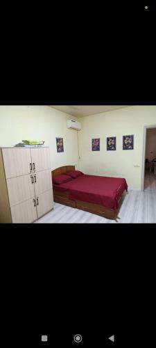 a bedroom with a bed with a red blanket at Asian Guest House in Bishkek