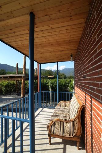 a bench on a porch with a wooden roof at ILIAS Guest House in Kvareli