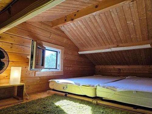 Bett in einem Blockhaus mit Fenster in der Unterkunft Ferienhaus Bootsmann in Plau am See