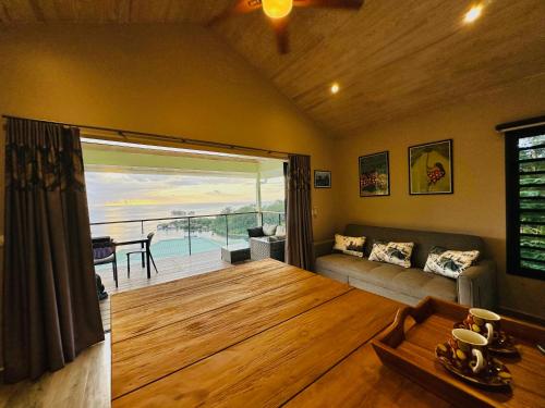 a living room with a couch and a table at Lilikoi Bungalow in Uturoa