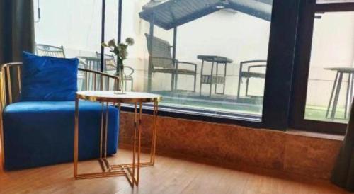 a blue couch and a table in front of a window at Magnotel Shenyang Consulate Qingnian Street in Shenyang