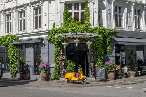 a yellow scooter parked in front of a building at Axel Guldsmeden in Copenhagen