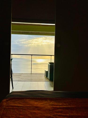 a room with a view of the ocean through a door at Lilikoi Bungalow in Uturoa