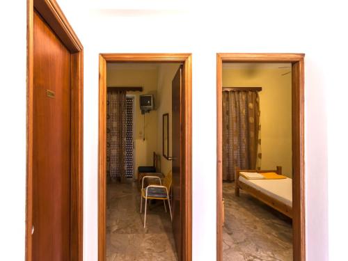 two doors to a room with a bed and a bedroom at Pension Vienna in Methana