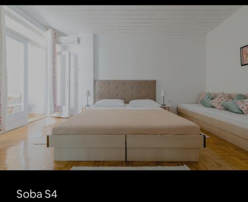 a white bedroom with a bed and a couch at Brela S1 S4-no parking in Brela
