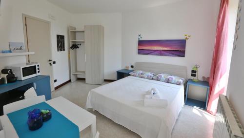 a bedroom with a white bed and a tv at Camera Molly in Cannero Riviera