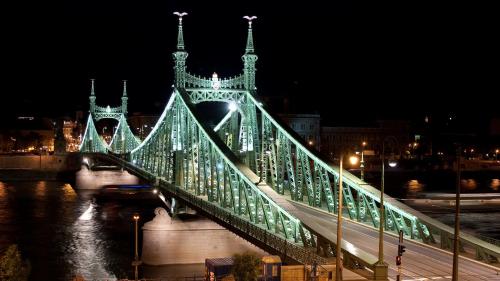 a bridge over a river at night at Charm Hotel Budapest - formerly Boutique Hotel Budapest in Budapest