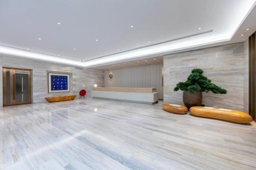 a lobby with a large room with a potted plant at Ji Hotel Shanghai Changshou Road - Near Metro Line 13&14,Free Luggage Storage,English Service in Shanghai