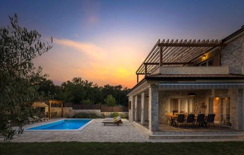 a house with a pool and a table and chairs at Villa LuLu kamena villa s maslinikom otok Krk Dobrinj selo Gostinjac in Krk