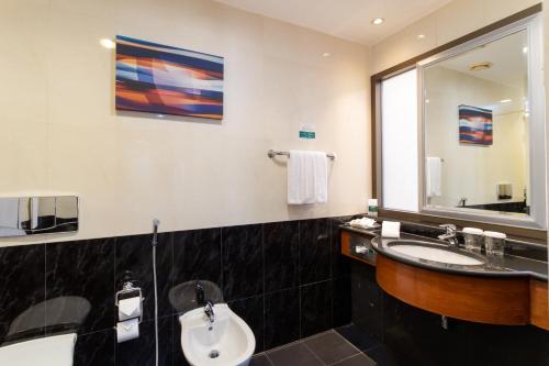 a bathroom with a sink and a mirror at Holiday Inn - Suites Kuwait Salmiya by IHG in Kuwait