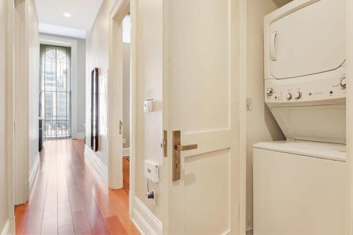 a hallway with a white door and a laundry room at Roami at Factors Row in New Orleans