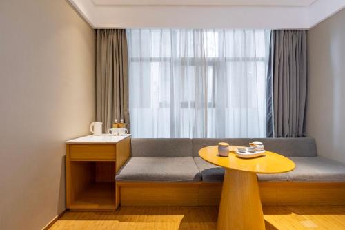 a room with a bench with a table and a window at Ji Hotel Shanghai Changshou Road - Near Metro Line 13&14,Free Luggage Storage,English Service in Shanghai