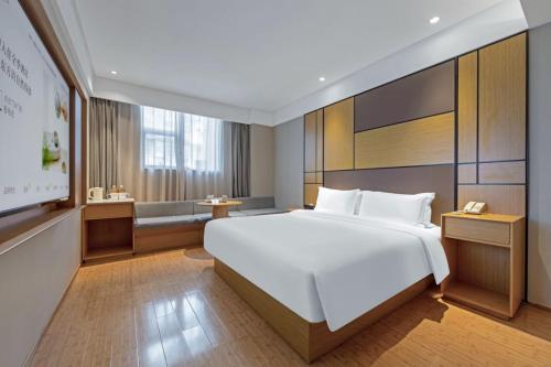 a bedroom with a large white bed and a desk at Ji Hotel Shanghai Changshou Road - Near Metro Line 13&14,Free Luggage Storage,English Service in Shanghai