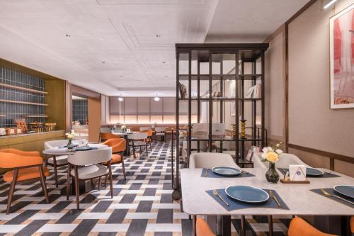 a dining room with tables and chairs at Beijing Guanganmen Niujie Manxin Hotel in Beijing