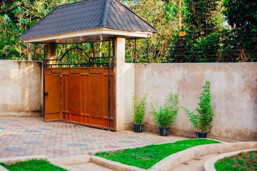 a wooden gate with a gazebo in a garden at Yoyo Celestial Home in Arusha
