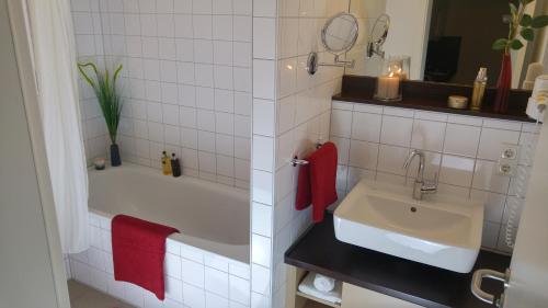 a bathroom with a white tub and a sink at Apartmenthotel Quartier M in Leipzig