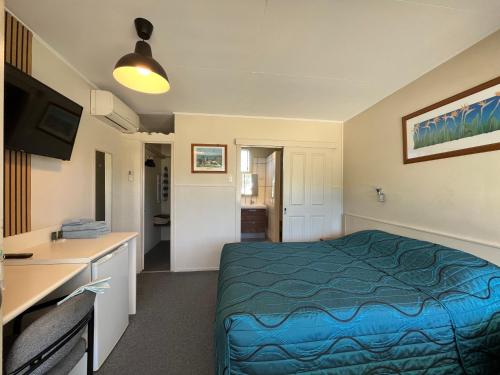 una habitación de hotel con una cama y un escritorio en Inglewood Motel, en Inglewood