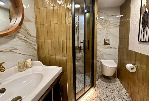 a bathroom with a sink and a shower and a toilet at Avra Guesthouse in Limenas