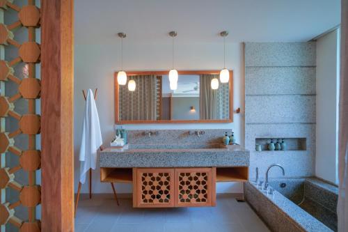 a bathroom with a sink and a mirror at Mia Resort Nha Trang in Nha Trang