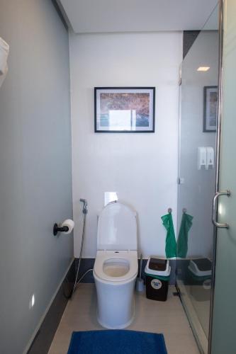 a bathroom with a toilet with a picture on the wall at AV Suites in Puerto Galera
