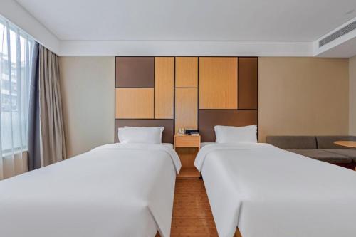 a hotel room with two beds and a couch at Ji Hotel Shanghai Changshou Road - Near Metro Line 13&14,Free Luggage Storage,English Service in Shanghai