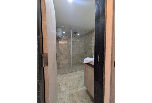 a shower with a glass door in a bathroom at Haritwal Guest House in Varanasi