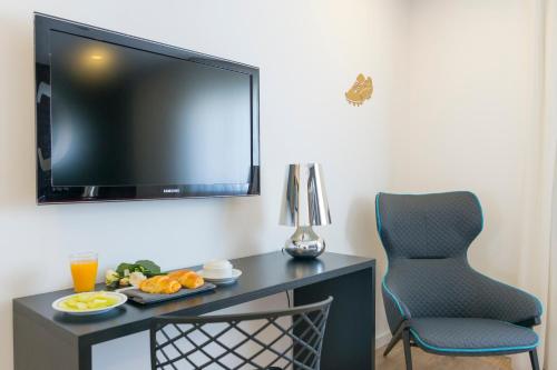 a room with a desk with a television and a chair at Sport Hotel A Seleção in Setúbal