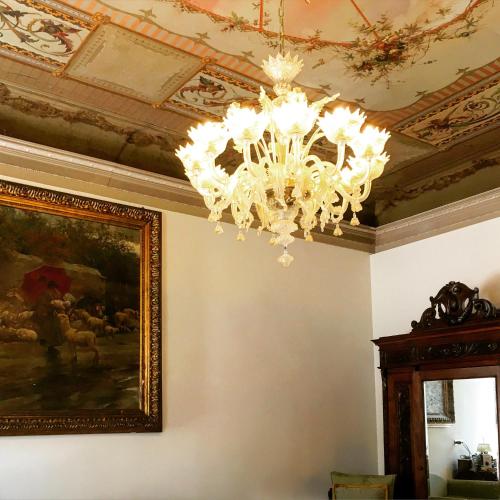 a chandelier hanging from a ceiling with a painting at Hotel Sant'Antonin in Venice