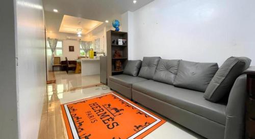 a living room with a gray couch and an orange rug at Pilot Hotel in Alaminos