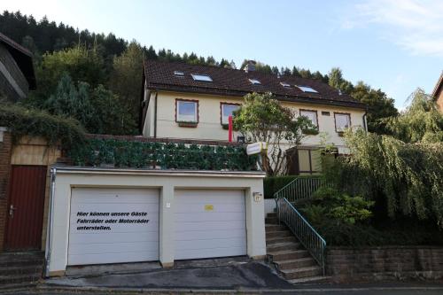 a house with a garage with a sign on it at Birkenstübchen in Lautenthal