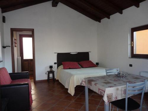 a bedroom with a bed and a table and a window at Il Basciutin in Pettenasco