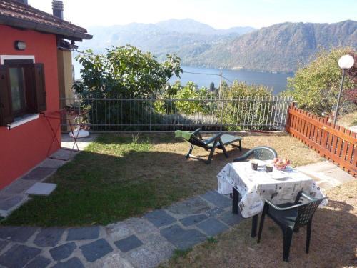 eine Terrasse mit einem Tisch und Stühlen sowie Seeblick in der Unterkunft Il Basciutin in Pettenasco