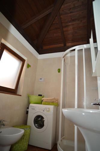 ein Badezimmer mit einer Waschmaschine und einem Waschbecken in der Unterkunft Il Basciutin in Pettenasco