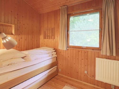a bed in a wooden room with a window at 6 person holiday home in Gilleleje in Gilleleje