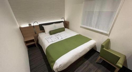 a bedroom with a green and white bed with a window at KEIKYU EX INN Hamamatsucho Daimon-Station (Tokyo) in Tokyo