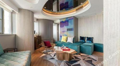 a living room with a blue couch and a table at Ethos Hotel Wuhan Riverside in Wuhan