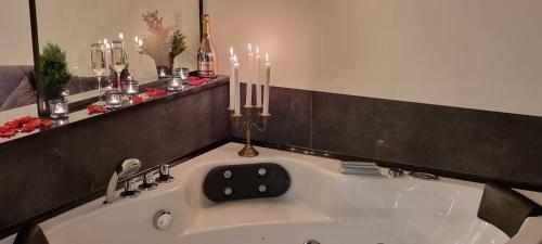 a bathroom with a bath tub with candles on the wall at Happy time together apartament z Jacuzzi in Wojkowice